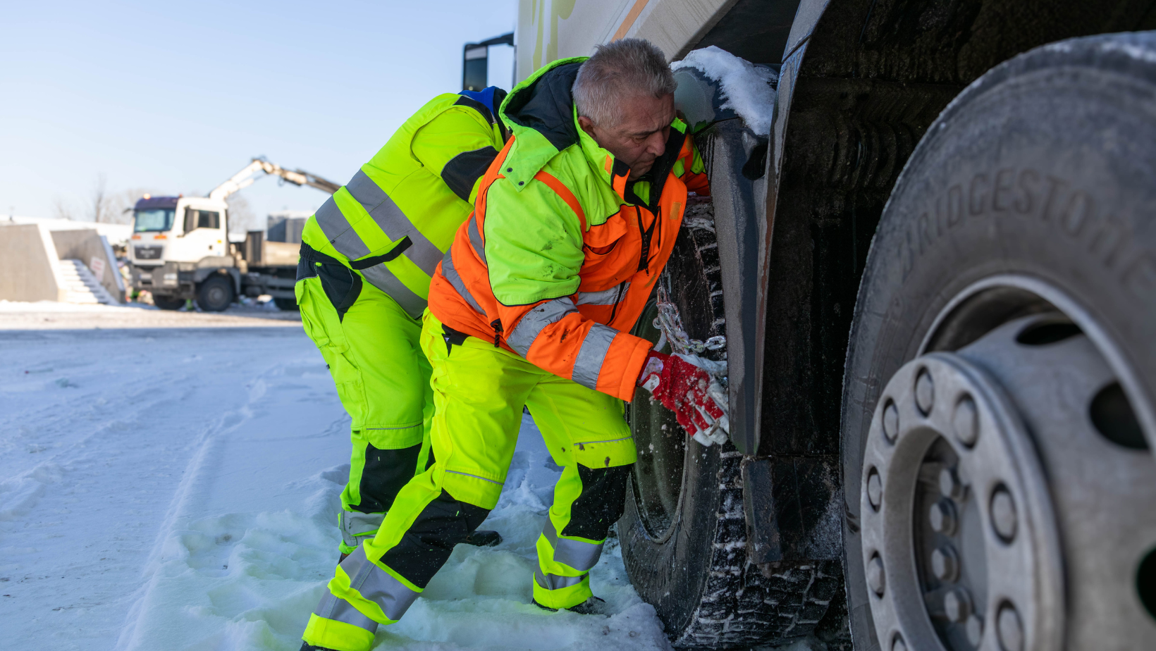 Hóláncot felszerelő munkások